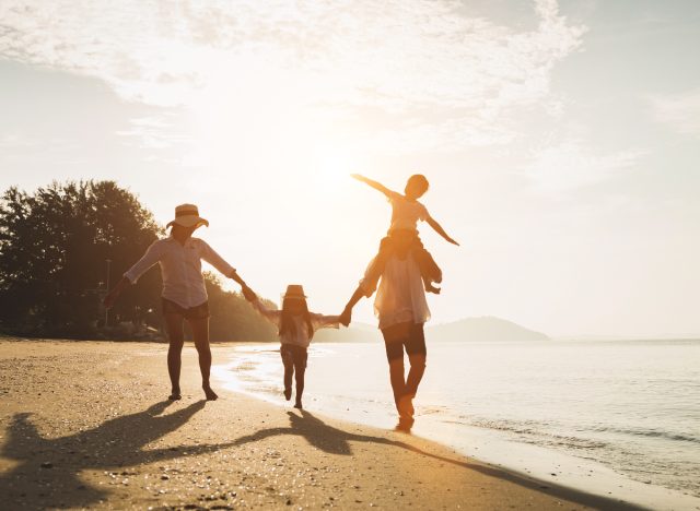 happy family walks on beach on sunny day