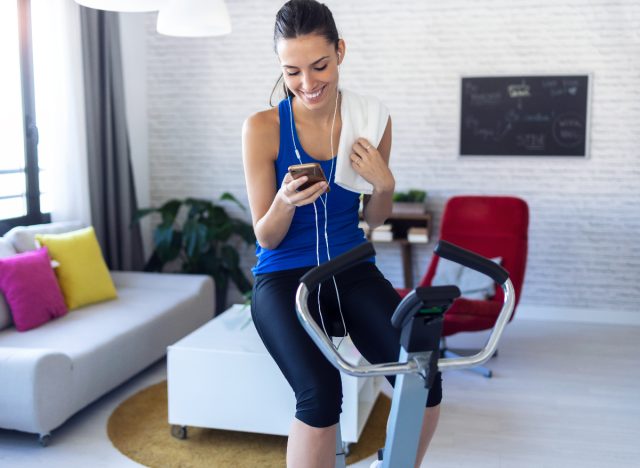 woman smiles as she takes a break from indoor cycling workout
