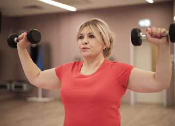 woman does exercise with dumbbells for upper body