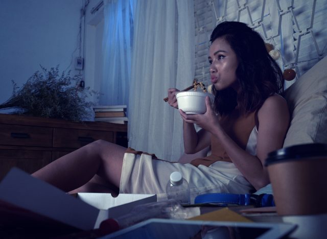 woman eating in bed before going to sleep