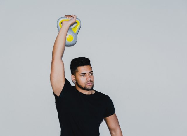 man holding kettlebell up in arm