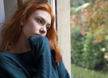 woman sad looking out window