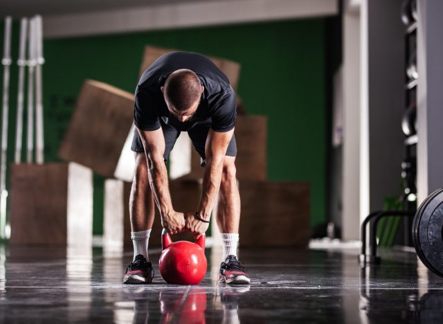 man does kettlebell deadlift to shrink belly fat faster