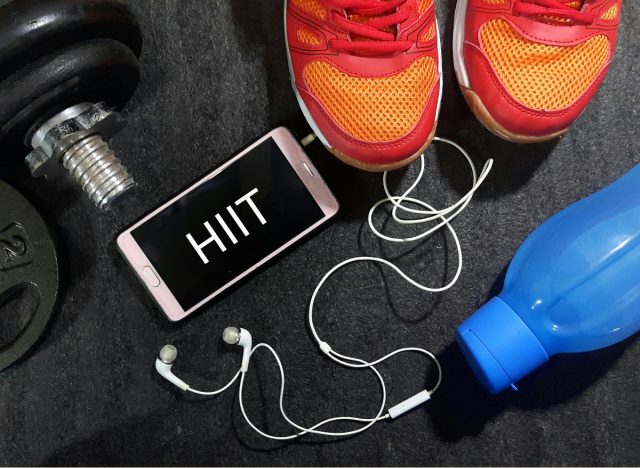 Hiit concept photos with phone, sneakers, gym equipment, water bottle