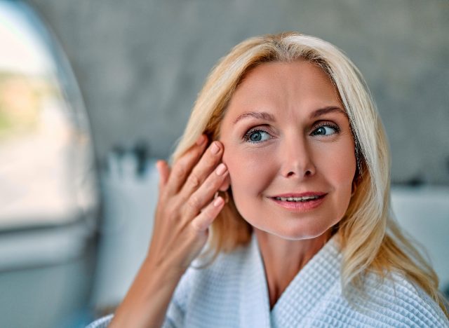 older woman admiring her youthful facial skin