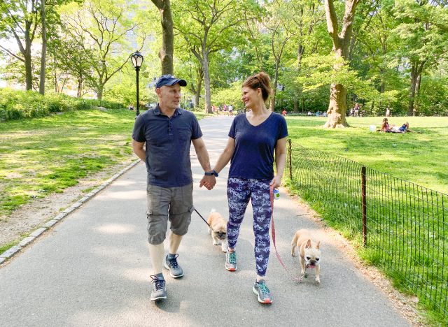 couple walking in park with their dogs