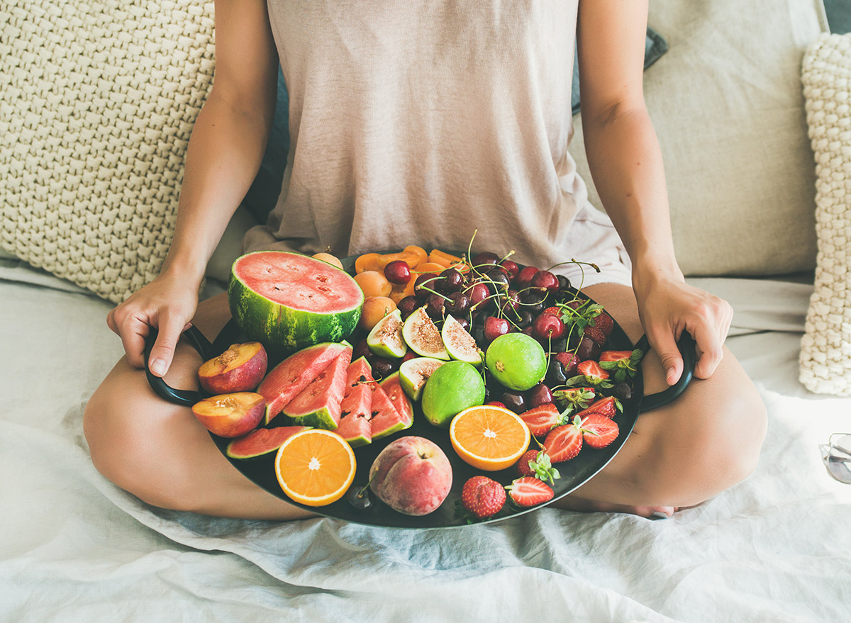 holding a platter of fruit