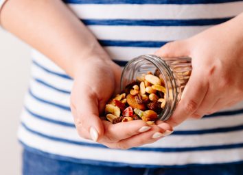 holding a jar of nuts and dried fruits