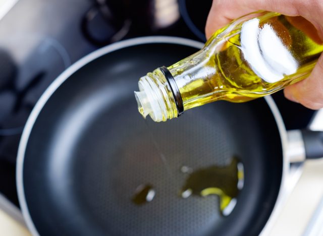 pouring olive oil into pan