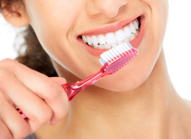 smiling woman brushing teeth