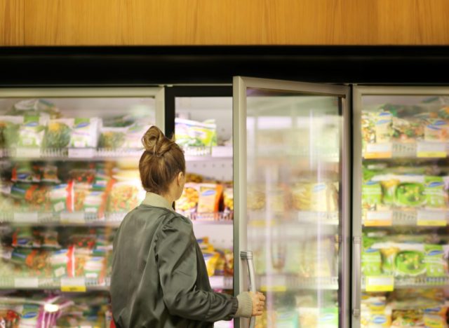 woman choosing frozen food at grocery store