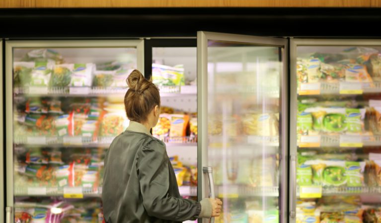 woman choosing frozen food at grocery store