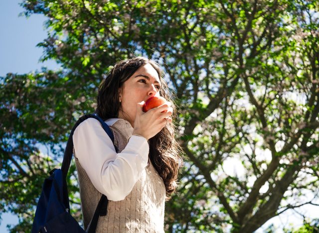 woman eating an apple outside