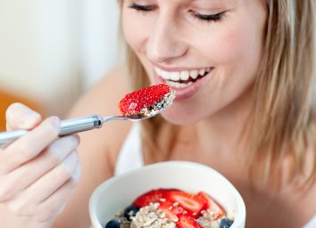 woman eating berries with yogurt and oats