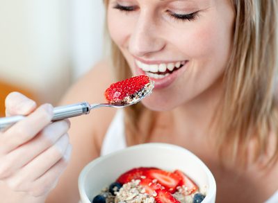 woman eating berries with yogurt and oats