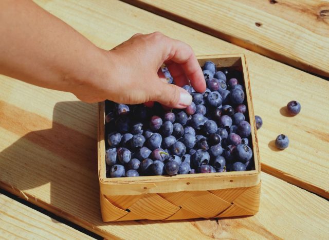 Picking at Basket of Blueberries