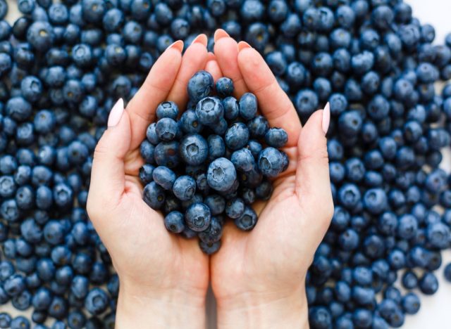 Holding a bunch of blueberries