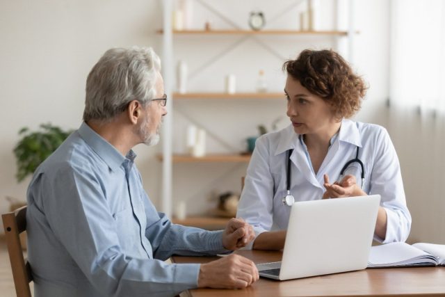 middle-aged man chatting with doctor