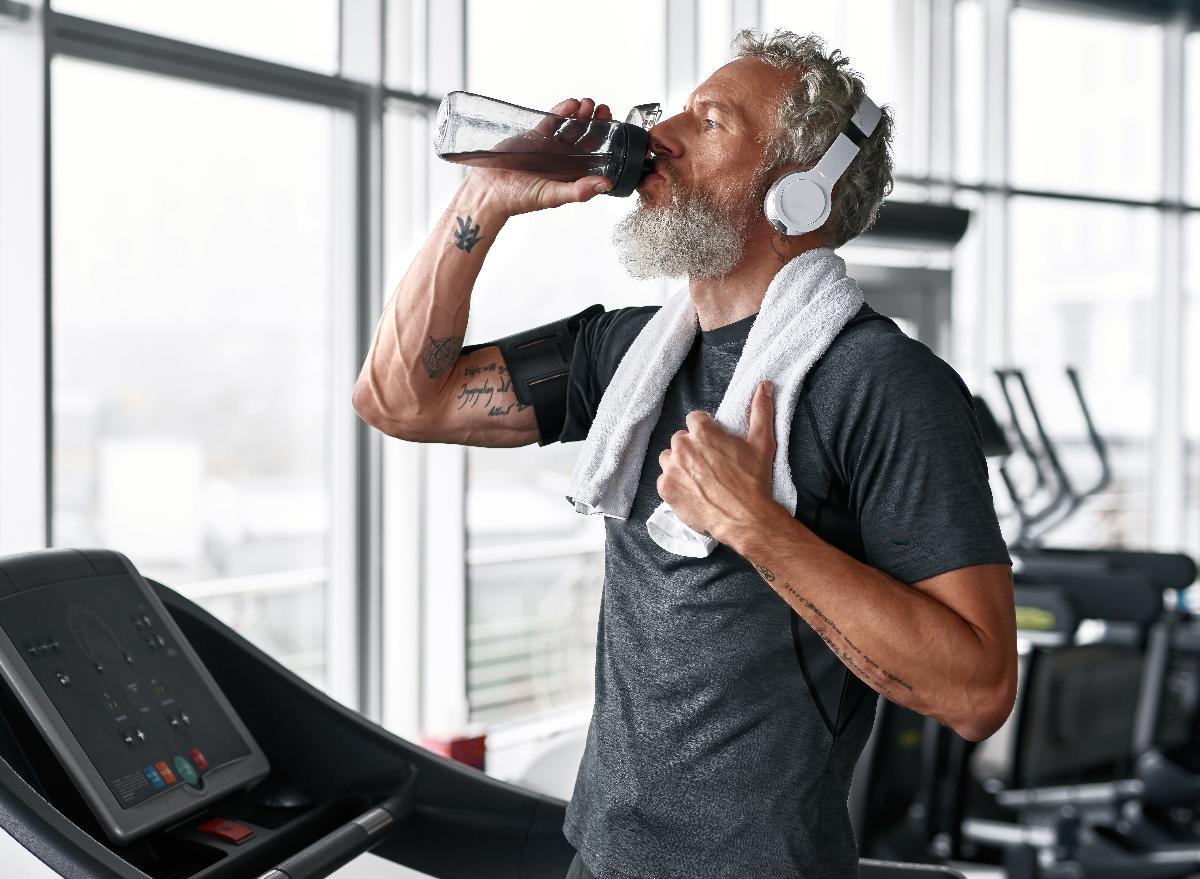 mature man drinking water while working out