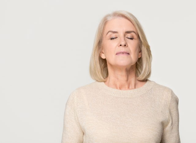 mature woman doing face exercise to get rid of sagging skin under chin