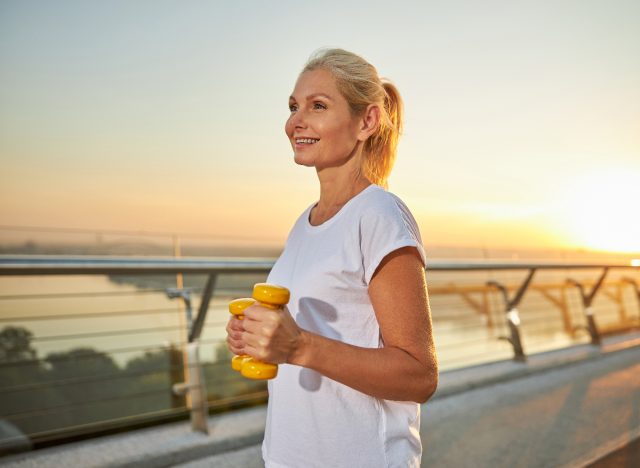 happy woman does walking workout at sunset, concept of fitness mistakes at 50