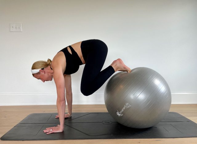 trainer demonstrating reverse crunch stability ball exercise