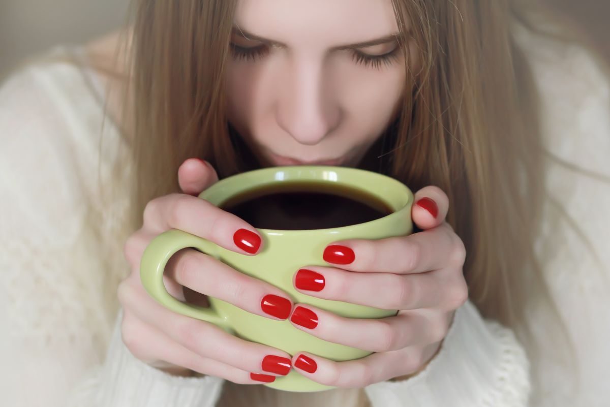 Woman with red nails Drinking Coffee