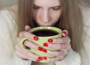 Woman with red nails Drinking Coffee