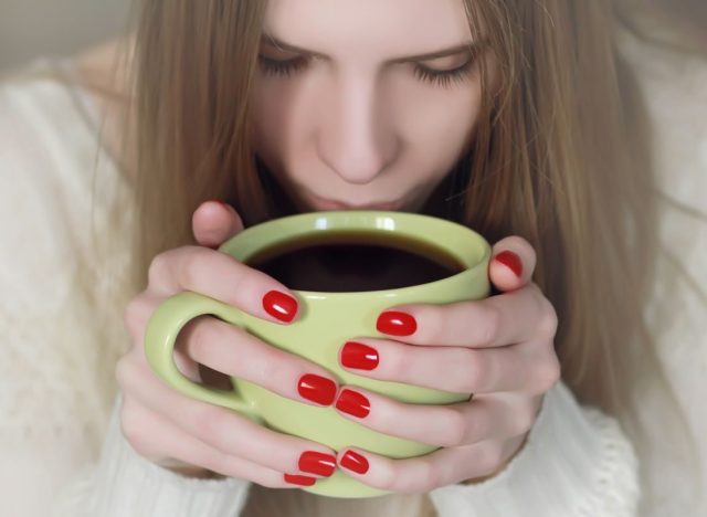 Woman with red nails Drinking Coffee