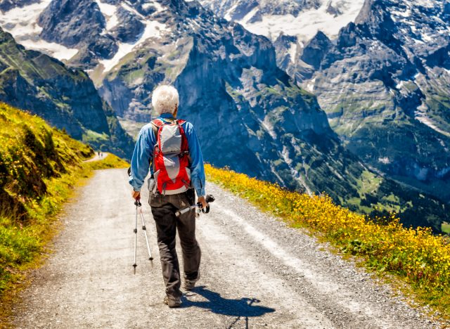 An active senior man walks through the mountains