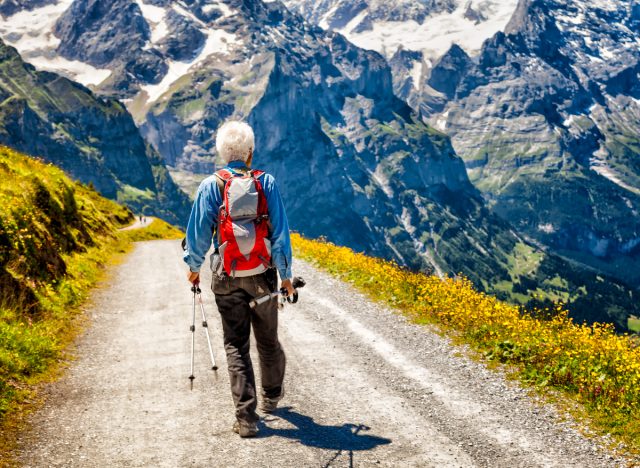 Aktiver großer Mann, der durch die Berge wandert