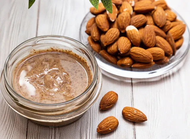 bowl of almonds next to bowl of almond butter