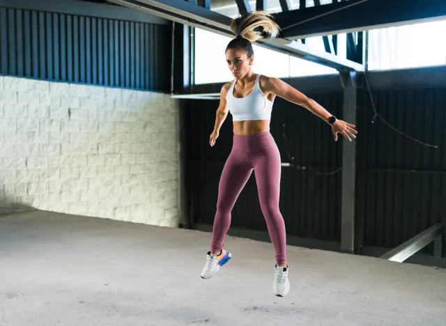 woman doing burpees exercise in gym to shrink belly fat