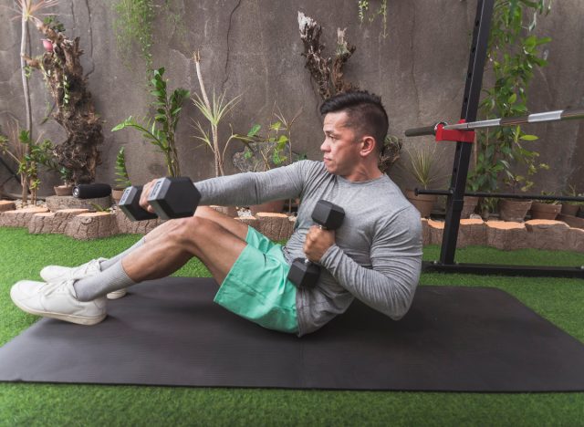 man doing core exercise with dumbbells to speed up belly fat loss