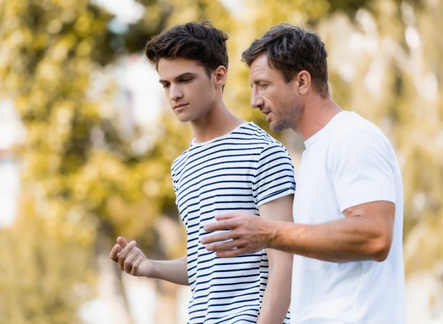 father and son walk outside and talk about mental heath