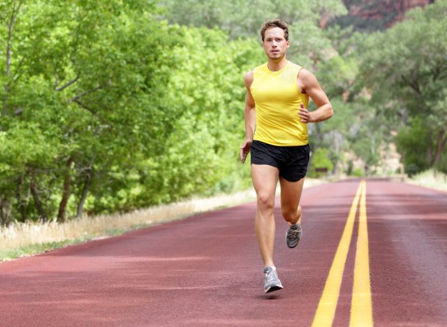 fit man long-distance running along trail, an exercise to shrink a flabby stomach