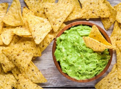 a bowl of guacamole surrounded by tortilla chips