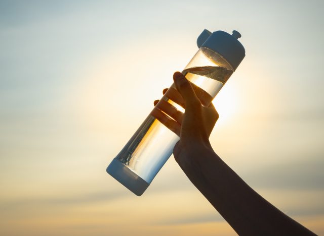 holding reusable water bottle