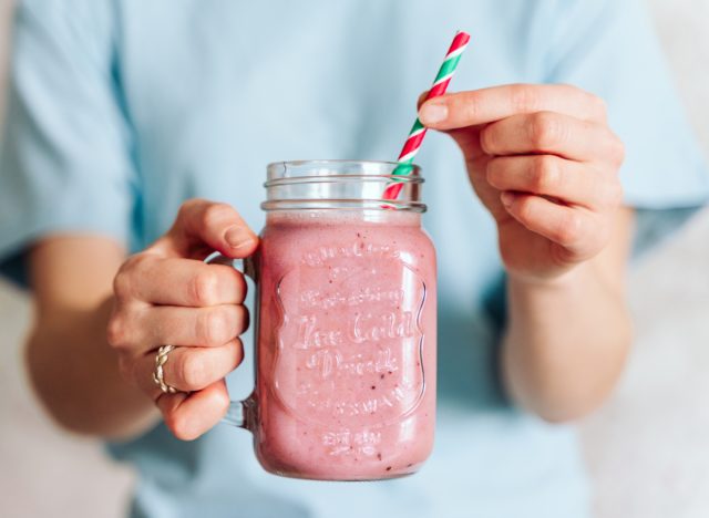 holding strawberry smoothie