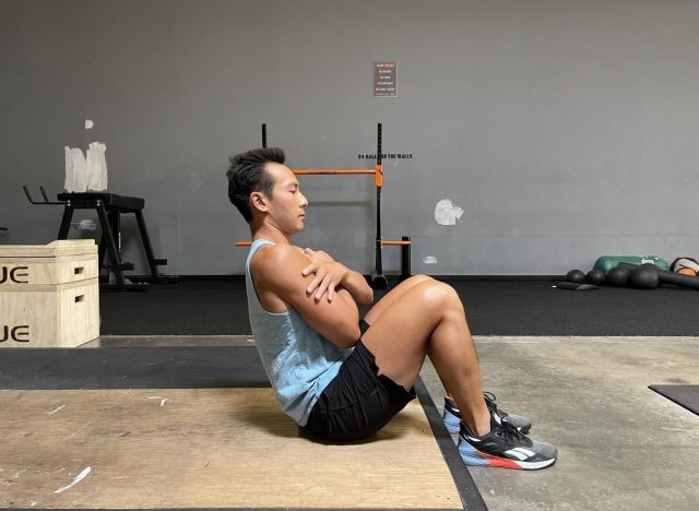 trainer doing janda situp in gym