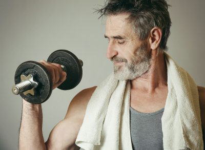 man in his 60s lifting weights, quitting unhealthy exercise habits