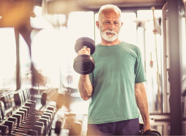 mature man demonstrating single overhead dumbbell press to shrink your waistline