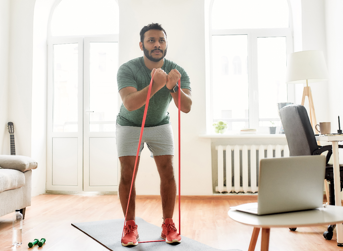 man doing resistance band workout at home
