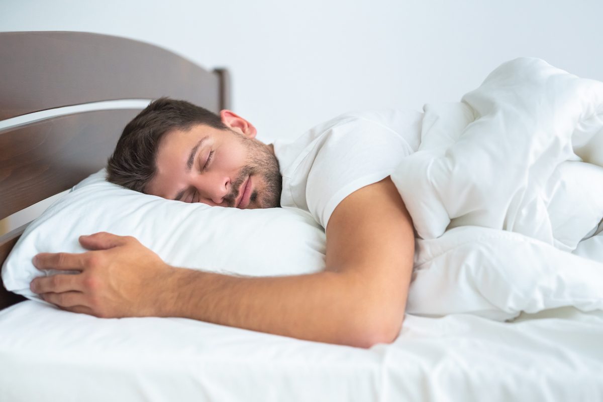 man sleeps peacefully in comfy sheets