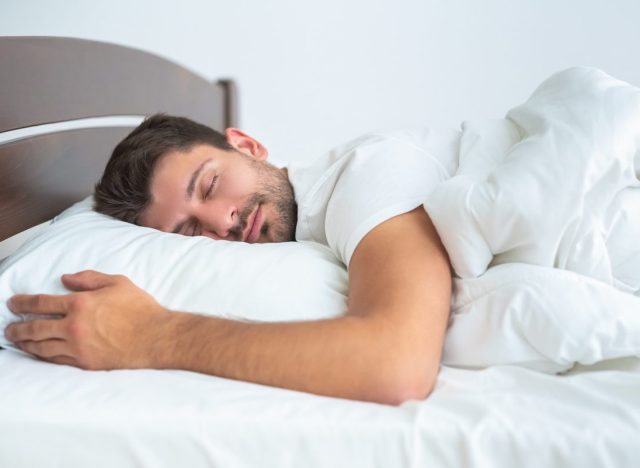 man sleeps peacefully in comfy sheets