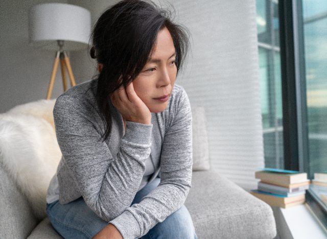 woman on couch at home, stressed