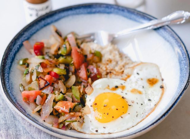savory oatmeal with sauteed peppers and onions with a fried egg