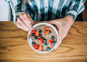 person eating oatmeal in the morning with berries
