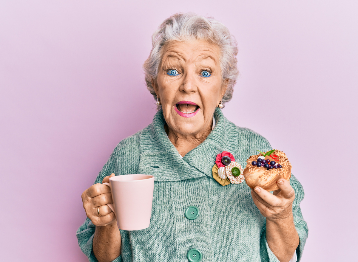 old woman eating and drinking coffee