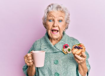 old woman eating and drinking coffee